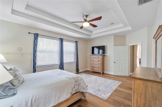 6017 NW 56th Cir, Coral Springs, FL 33067 - bedroom with a tray ceiling, light wood-style flooring, and ceiling fan