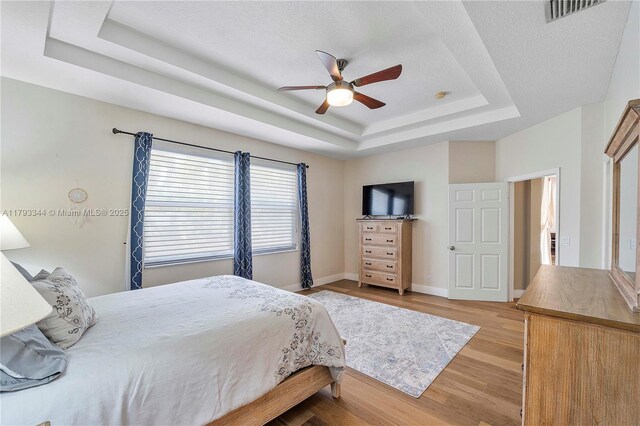 6017 NW 56th Cir, Coral Springs, FL 33067 - bedroom with a tray ceiling, light wood-style flooring, and ceiling fan