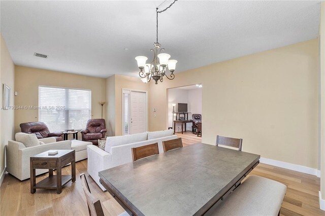 6017 NW 56th Cir, Coral Springs, FL 33067 - dining space with a chandelier and light wood-style floors