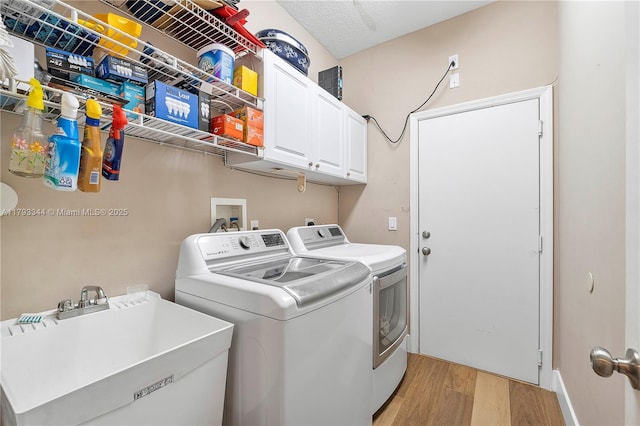 6017 NW 56th Cir, Coral Springs, FL 33067 - washroom featuring light wood-style floors, washer and clothes dryer, and cabinet space