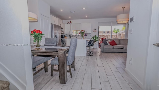 dining room with recessed lighting, light wood finished floors, and visible vents