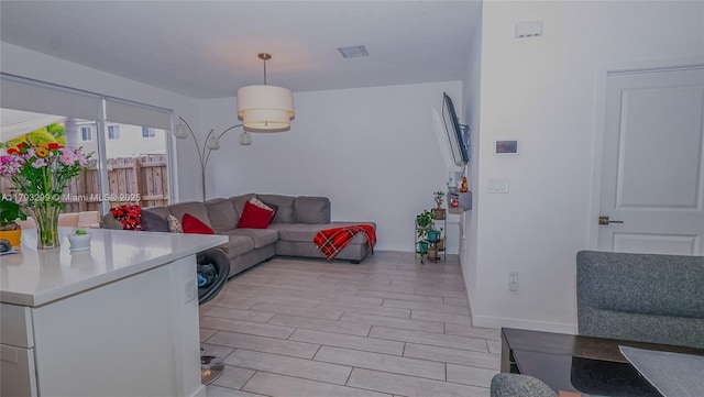 living room featuring baseboards, visible vents, and light wood-type flooring