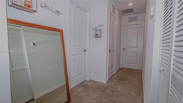 corridor featuring carpet floors, baseboards, and visible vents