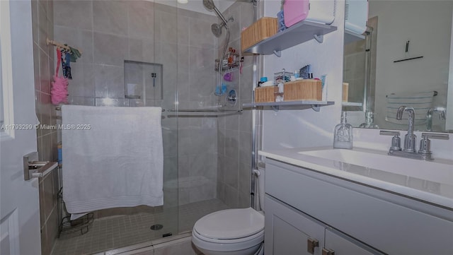 bathroom featuring vanity, a shower stall, and toilet