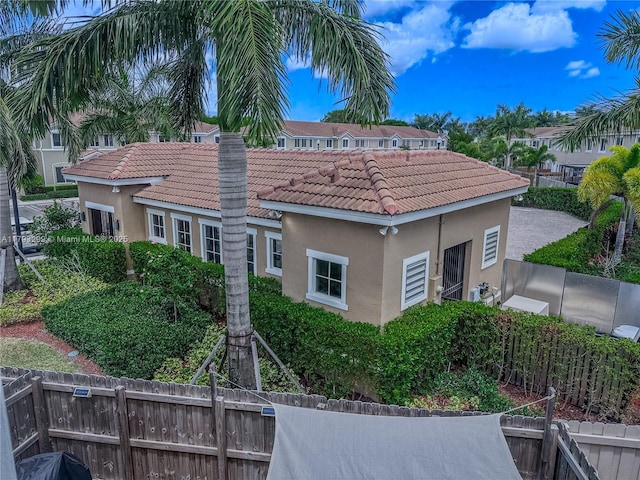 view of property exterior with fence, a chimney, a tile roof, and stucco siding