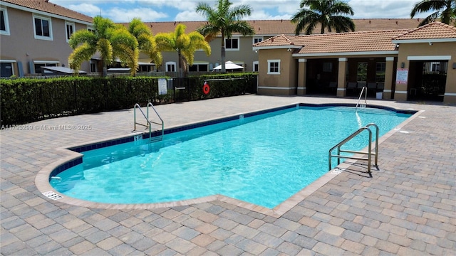 community pool featuring a patio area and fence