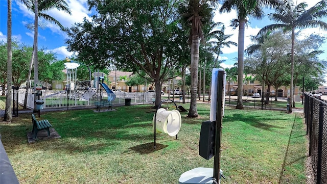 view of community with a lawn, fence, and playground community