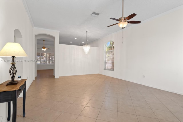 empty room with a healthy amount of sunlight, crown molding, ceiling fan with notable chandelier, and visible vents