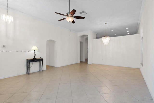 unfurnished room featuring arched walkways, visible vents, light tile patterned floors, and ceiling fan with notable chandelier