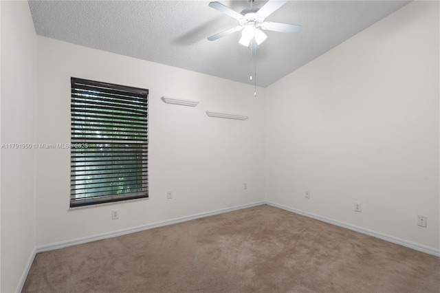 carpeted spare room featuring vaulted ceiling, baseboards, a ceiling fan, and a textured ceiling