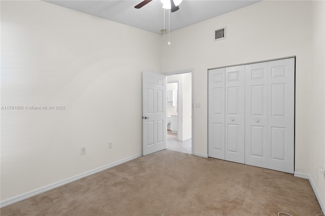 unfurnished bedroom featuring a ceiling fan, visible vents, baseboards, a closet, and carpet
