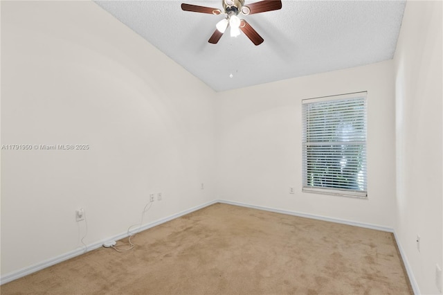 spare room featuring carpet floors, a textured ceiling, baseboards, and ceiling fan