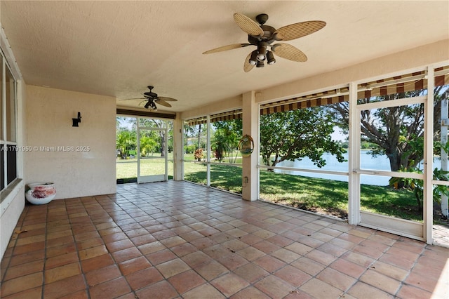unfurnished sunroom with a water view and ceiling fan