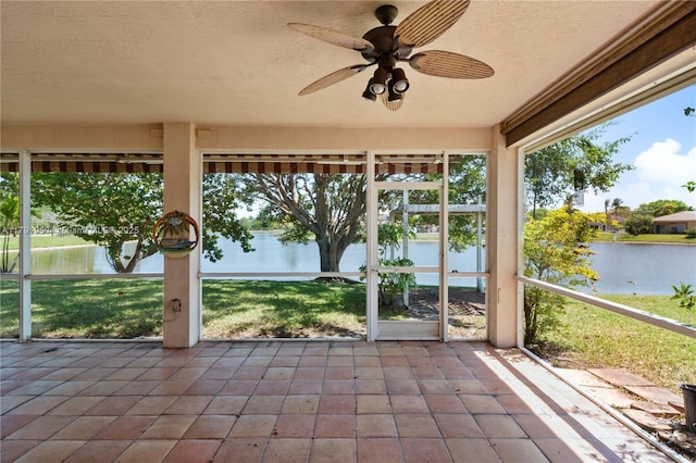 unfurnished sunroom featuring a water view and ceiling fan