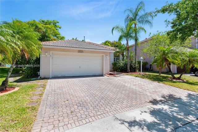 ranch-style home featuring decorative driveway, a front lawn, a tile roof, and stucco siding