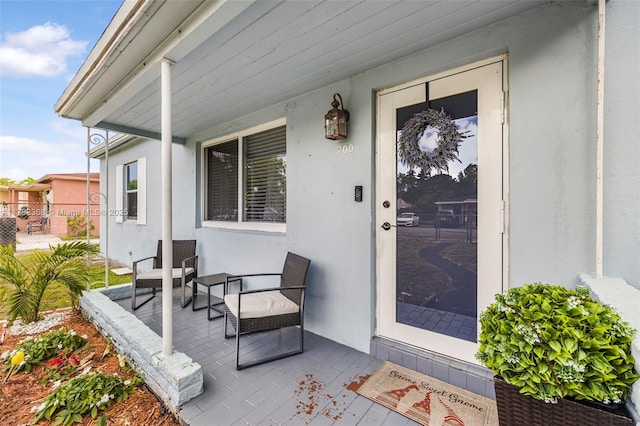 entrance to property with stucco siding and a porch
