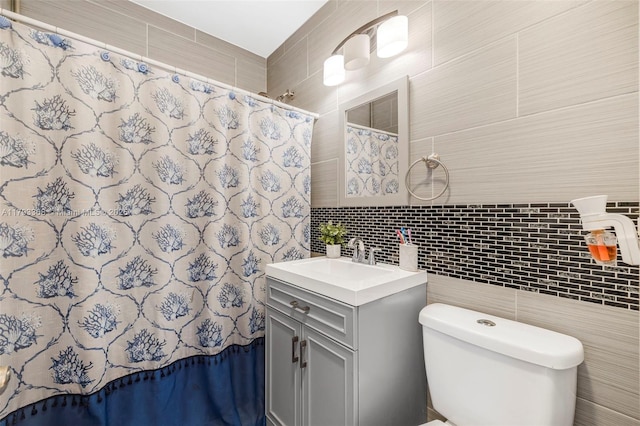 bathroom with vanity, toilet, tile walls, curtained shower, and tasteful backsplash
