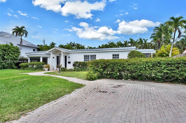 255 Ridgewood Rd, Key Biscayne, FL 33149 - ranch-style house with a front yard, stucco siding, metal roof, and a standing seam roof