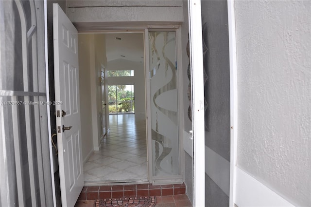 hallway with tile patterned flooring and a textured wall
