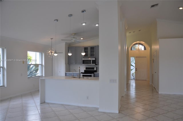 kitchen with crown molding, light tile patterned floors, baseboards, light countertops, and stainless steel appliances