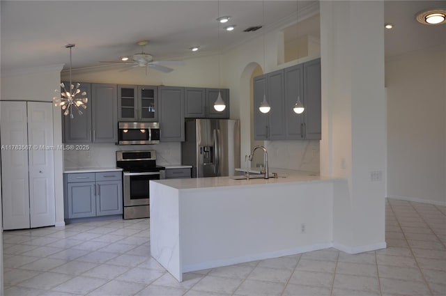 kitchen featuring stainless steel appliances, gray cabinetry, ornamental molding, and a sink