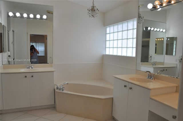 bathroom featuring a sink, a bath, tile patterned floors, and two vanities