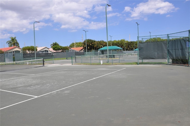 view of tennis court featuring fence