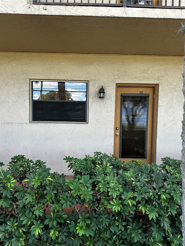 entrance to property featuring stucco siding