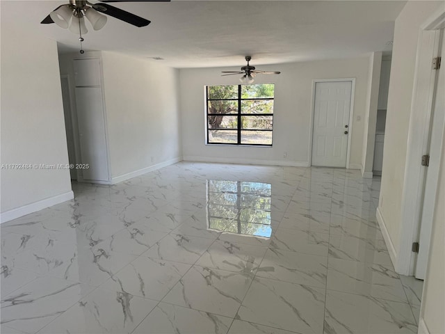 unfurnished room featuring baseboards, a ceiling fan, and marble finish floor