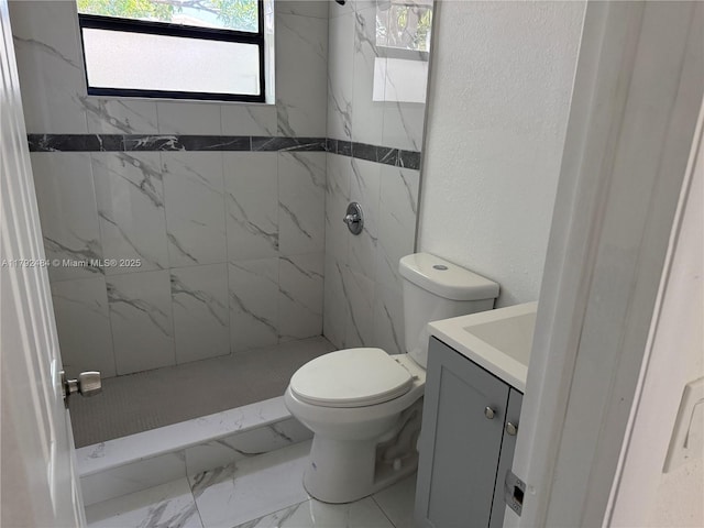 bathroom featuring vanity, toilet, a marble finish shower, and marble finish floor