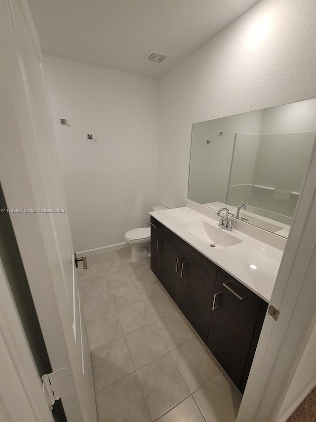 half bath with vanity, tile patterned floors, toilet, and visible vents