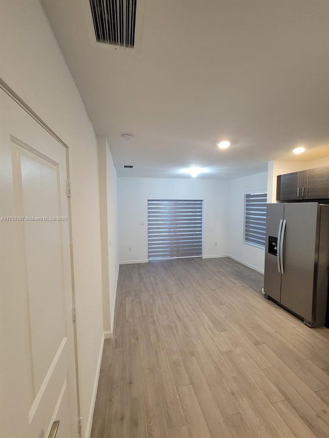 unfurnished living room with visible vents, recessed lighting, baseboards, and light wood-type flooring