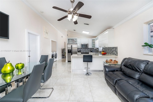 6829 W 26th Ave, Hialeah, FL 33016 - living room with crown molding, visible vents, a ceiling fan, vaulted ceiling, and washer and clothes dryer
