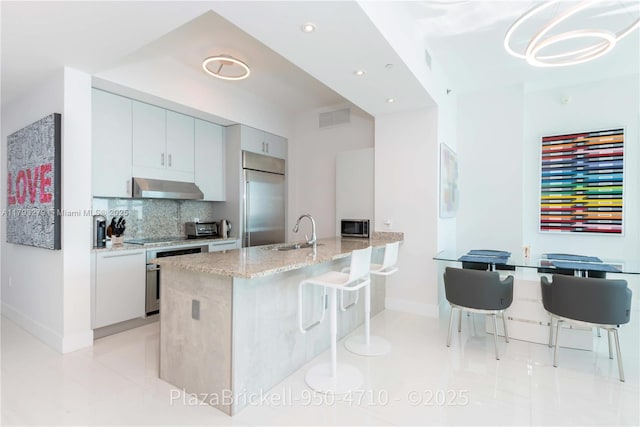 950 Brickell Bay Dr Unit 4710, Miami, FL 33131 - kitchen with built in refrigerator, a sink, baseboards, light stone countertops, and oven
