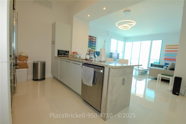 950 Brickell Bay Dr Unit 4710, Miami, FL 33131 - kitchen featuring a peninsula, appliances with stainless steel finishes, a sink, and light tile patterned floors