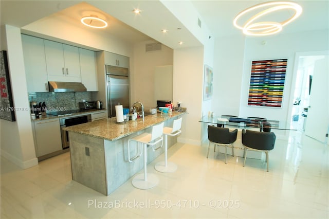 950 Brickell Bay Dr Unit 4710, Miami, FL 33131 - kitchen with tasteful backsplash, wall oven, baseboards, stainless steel built in refrigerator, and extractor fan