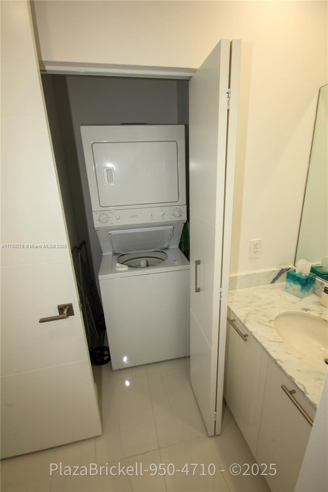 950 Brickell Bay Dr Unit 4710, Miami, FL 33131 - washroom with light tile patterned floors, laundry area, stacked washing maching and dryer, and a sink