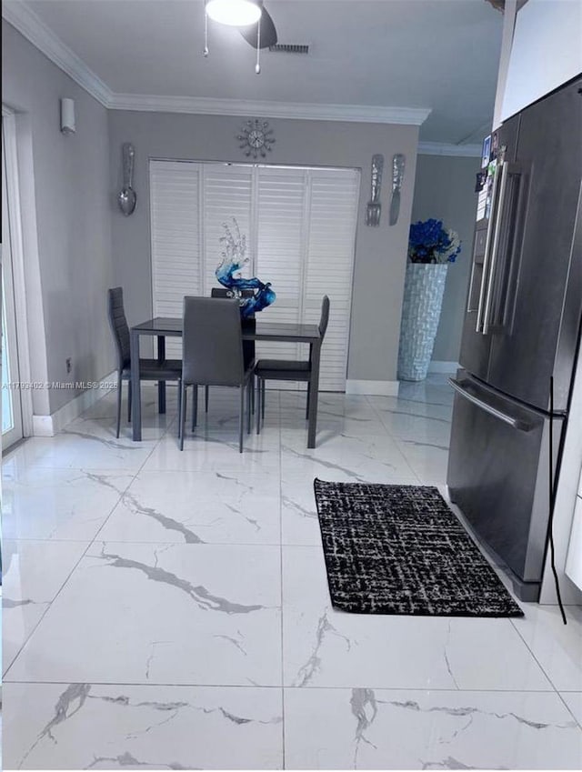 dining area with baseboards, ornamental molding, and marble finish floor
