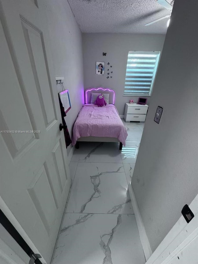 bedroom with a textured ceiling and marble finish floor