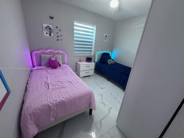 bedroom with a textured ceiling and marble finish floor