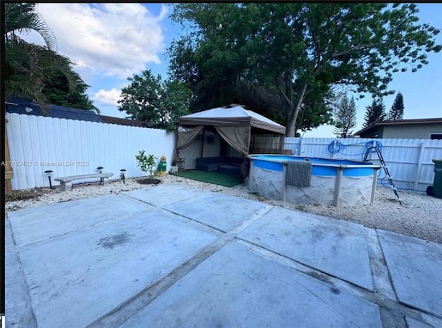 view of swimming pool featuring a patio, a gazebo, a fenced in pool, and a fenced backyard
