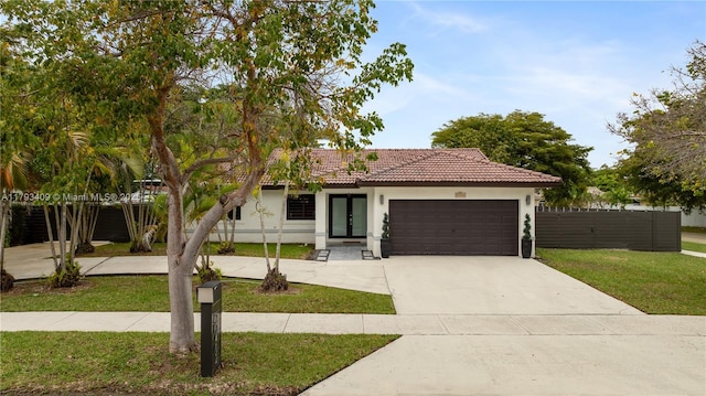 view of front of home featuring a front yard, fence, concrete driveway, an attached garage, and stucco siding