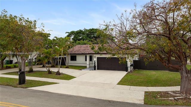 view of front of home with an attached garage, stucco siding, driveway, and a front lawn