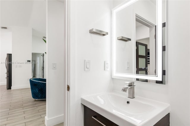 bathroom featuring baseboards, visible vents, wood finished floors, and vanity