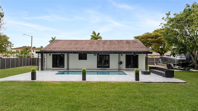 rear view of house featuring french doors, fence, a patio, and a tile roof