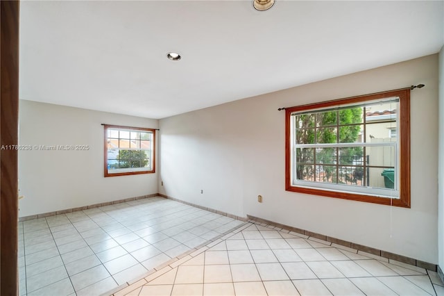 unfurnished room with baseboards and light tile patterned floors
