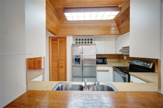 kitchen with light countertops, white cabinetry, under cabinet range hood, a sink, and stainless steel appliances