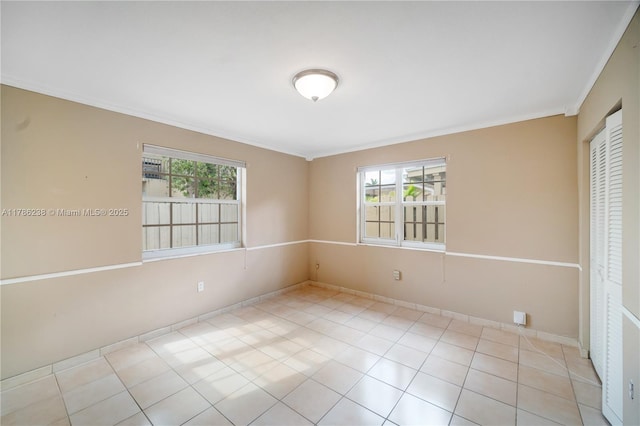 empty room with crown molding, baseboards, and a wealth of natural light