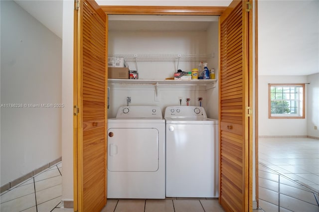washroom featuring light tile patterned floors, baseboards, laundry area, and independent washer and dryer