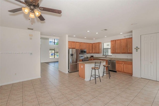 kitchen featuring a kitchen bar, visible vents, a center island, stainless steel appliances, and recessed lighting